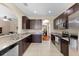 Open kitchen with stainless steel appliances, granite counters, and dark wood cabinets at 10837 Breaking Rocks Dr, Tampa, FL 33647