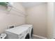 A bright laundry room features a washer, dryer, and wire shelving for storage at 10837 Breaking Rocks Dr, Tampa, FL 33647