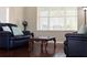 Comfortable living room with leather sofas, wood coffee table, large window, and wood floors at 10837 Breaking Rocks Dr, Tampa, FL 33647