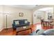 Open-concept living room with dark wood floors, leather sofas, arched doorway to dining room, and plenty of natural light at 10837 Breaking Rocks Dr, Tampa, FL 33647