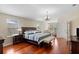 Spacious primary bedroom features hardwood floors, a king bed, and lots of windows for natural light at 10837 Breaking Rocks Dr, Tampa, FL 33647