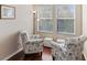 Bright sitting area with floral chairs, light colored ottomans, hardwood floors, and large windows at 10837 Breaking Rocks Dr, Tampa, FL 33647