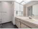 Bathroom features a vanity with ample countertop space, cabinets, a large mirror, and a shower at 1103 Old Mill Pond Rd, Palm Harbor, FL 34683