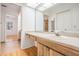 Well-lit bathroom with a light wood vanity, spacious countertop, and access to other rooms at 1103 Old Mill Pond Rd, Palm Harbor, FL 34683