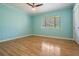 Bedroom with light blue walls, light hardwood floors, and closet, offering a calming retreat at 1103 Old Mill Pond Rd, Palm Harbor, FL 34683