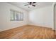 An empty bedroom featuring warm wood floors, a ceiling fan, and natural light from a window at 1103 Old Mill Pond Rd, Palm Harbor, FL 34683