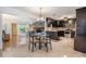 Dining area adjacent to kitchen with dark wood cabinets, granite countertops, and open view to living room with stone fireplace at 1103 Old Mill Pond Rd, Palm Harbor, FL 34683