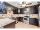Modern kitchen featuring dark wood cabinetry, stainless steel appliances, granite counters, and mosaic tile backsplash at 1103 Old Mill Pond Rd, Palm Harbor, FL 34683
