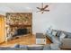 Inviting living room with stone fireplace, light hardwood floors, and comfortable couches at 1103 Old Mill Pond Rd, Palm Harbor, FL 34683