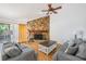 Bright living room featuring a stone fireplace, ceiling fan, and comfortable seating at 1103 Old Mill Pond Rd, Palm Harbor, FL 34683