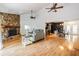 Open-concept living area with a stone fireplace, and view of the kitchen and dining area at 1103 Old Mill Pond Rd, Palm Harbor, FL 34683