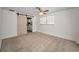 Light-filled bedroom with ceiling fan and barn door to bathroom at 1212 Royal Oak Dr, Dunedin, FL 34698