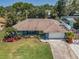 Well-maintained home featuring an attached garage, green lawn, and landscaping at 1212 Royal Oak Dr, Dunedin, FL 34698