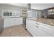 Spacious kitchen with white cabinetry, granite countertops, and stainless steel appliances at 1212 Royal Oak Dr, Dunedin, FL 34698