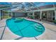 Backyard view featuring sparkling in-ground pool and covered patio, perfect for outdoor entertaining at 1212 Royal Oak Dr, Dunedin, FL 34698