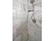 Close-up of the luxurious walk-in shower featuring marble-patterned tile and modern shower head fixture at 1212 Royal Oak Dr, Dunedin, FL 34698