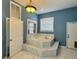 Bathroom featuring a marble-trimmed soaking tub and window with natural light at 12349 Wasatch Ct, New Port Richey, FL 34654