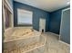 Bathroom featuring a marble-trimmed soaking tub and window with natural light at 12349 Wasatch Ct, New Port Richey, FL 34654