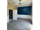 Well lit bedroom with blue accent wall, painted trim, and wood-look flooring at 12349 Wasatch Ct, New Port Richey, FL 34654