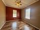 Cozy bedroom featuring hardwood floors, two windows, and a ceiling fan at 12349 Wasatch Ct, New Port Richey, FL 34654