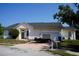 Beige single-story home with a two-car garage, brick driveway, and well-maintained landscaping at 12349 Wasatch Ct, New Port Richey, FL 34654
