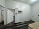 Bright laundry room with white cabinets, flooring, and doorway at 12349 Wasatch Ct, New Port Richey, FL 34654