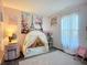 Pink bedroom with a play tent, rug, and decor, ideal for a young imagination at 12426 Dawn Vista Dr, Riverview, FL 33578