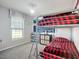 Bedroom featuring a bunk bed with bright red plaid bedding and a storage unit against a mountain mural at 12426 Dawn Vista Dr, Riverview, FL 33578