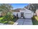 Charming single-story home featuring a well-manicured lawn, screened entry, and attached garage at 12426 Dawn Vista Dr, Riverview, FL 33578