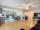 Bright open-plan view of living room to kitchen with hardwood floors, ceiling fan and stainless steel appliances at 12426 Dawn Vista Dr, Riverview, FL 33578