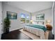 Modern bedroom featuring dark wood floors, bright windows, and a comfortable king bed with stylish decor and art at 1316 W Carmen St # 2, Tampa, FL 33606