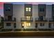 Townhouse exterior at dusk featuring modern design, balconies, and manicured landscaping at 1316 W Carmen St # 2, Tampa, FL 33606