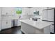 Bright kitchen features white cabinets, modern appliances, subway tile backsplash, and large island with quartz countertop at 1316 W Carmen St # 2, Tampa, FL 33606