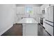 Modern kitchen featuring white cabinets, stainless steel appliances, and large island with quartz countertop at 1316 W Carmen St # 2, Tampa, FL 33606