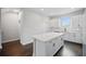 Spacious kitchen featuring white cabinets, subway tile backsplash, an island with a quartz countertop, and dark wood floors at 1316 W Carmen St # 2, Tampa, FL 33606