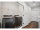 A well-organized laundry room equipped with a modern washer, dryer, storage, and shelving at 1316 W Carmen St # 2, Tampa, FL 33606