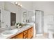Bathroom featuring double sinks, shower with glass door and lighting at 13310 Thoroughbred Loop, Largo, FL 33773