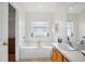 Bright bathroom with white tub, sink, and tiled flooring at 13310 Thoroughbred Loop, Largo, FL 33773