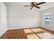 Bright bedroom with hardwood floors, ceiling fan, and natural light from the window at 13310 Thoroughbred Loop, Largo, FL 33773