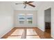 Bright bedroom featuring two windows, ceiling fan, and an ensuite bathroom entrance at 13310 Thoroughbred Loop, Largo, FL 33773