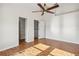 Bright bedroom featuring hardwood floors, ceiling fan and two entry ways at 13310 Thoroughbred Loop, Largo, FL 33773