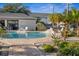 A view of the community pool with lounge chairs, a brick patio, and tropical plants at 13310 Thoroughbred Loop, Largo, FL 33773