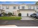 Inviting townhouse exterior with attached garage and manicured lawn at 13310 Thoroughbred Loop, Largo, FL 33773