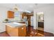 Bright kitchen featuring wood cabinets, white appliances, and a breakfast bar leading to adjacent bathroom at 13310 Thoroughbred Loop, Largo, FL 33773