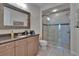 Elegant bathroom features a vanity, modern mirror, and glass-enclosed shower at 16406 Chapman Crossing Dr, Lithia, FL 33547