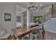 Elegant dining area featuring hardwood floors, a wooden table with bar stools, and decorative lighting fixtures at 16406 Chapman Crossing Dr, Lithia, FL 33547