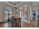 Spacious dining area with a wooden table, bar stools, hardwood floors, and views of the foyer and windows at 16406 Chapman Crossing Dr, Lithia, FL 33547