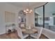 Bright dining area with modern light fixture, stylish bar cart, and large windows overlooking the backyard at 16406 Chapman Crossing Dr, Lithia, FL 33547