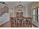 Open dining area with a Bourbon Bar, wooden table, bar stools, arched window, and hardwood floors at 16406 Chapman Crossing Dr, Lithia, FL 33547