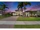Elegant two-story home featuring a paver driveway, manicured lawn, and stylish architectural details at 16406 Chapman Crossing Dr, Lithia, FL 33547
